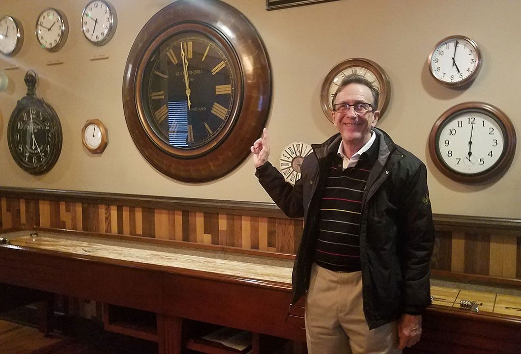 Architect Ward Bucher shows off the clocks on the walls at Clock Restoration REstaurant and Bar at QG